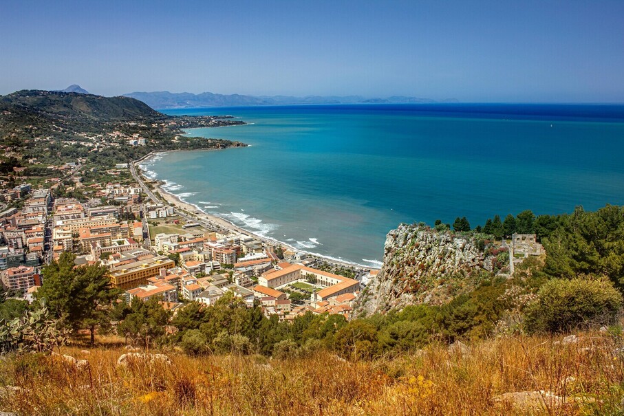 Stunning aerial view of a coastal town with clear blue waters and picturesque landscape.